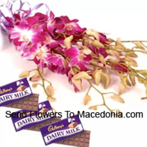 Un magnifique bouquet d'orchidées roses accompagné de chocolats assortis Cadbury